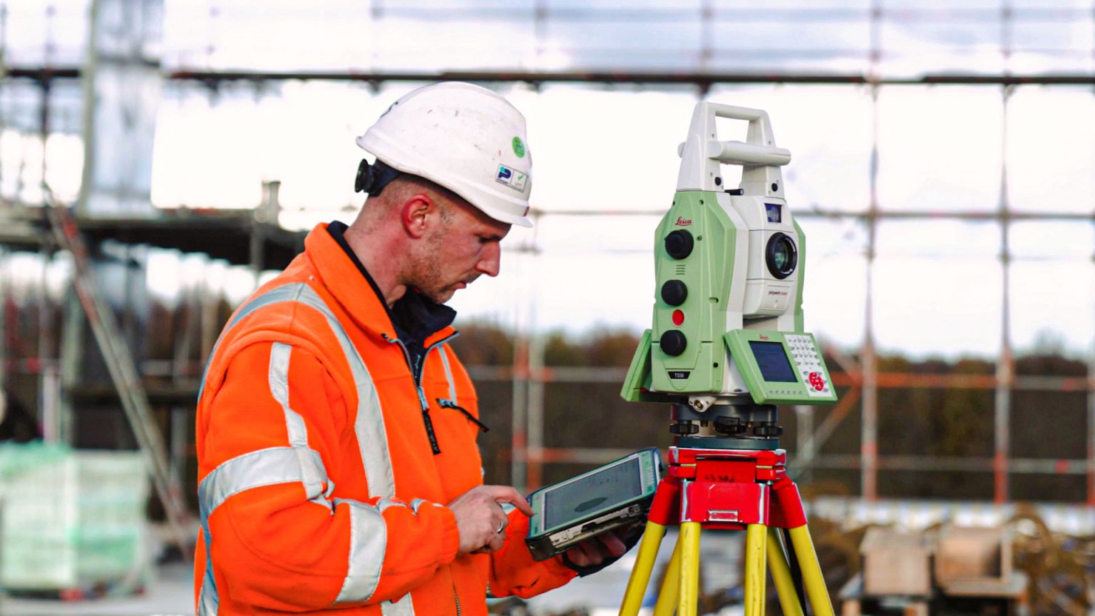 Landmeter voert uitzetwerk uit met een total station op een bouwplaats voor nauwkeurige maatvoering. Uitzetwerk met total station | Coenradie